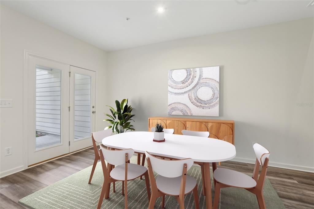 A dining room features a white oval table, four chairs, a wooden sideboard, and glass doors — 2566 GREY HAWK DRIVE,, KISSIMMEE, FL
