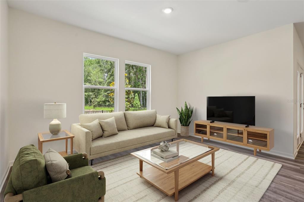 This is a digital rendering of a living room featuring a sofa, armchair, and television — 2566 GREY HAWK DRIVE,, KISSIMMEE, FL
