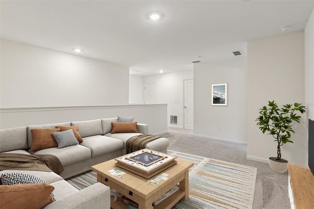 A living room features a sectional sofa, a wooden coffee table, and a potted plant — 2566 GREY HAWK DRIVE,, KISSIMMEE, FL