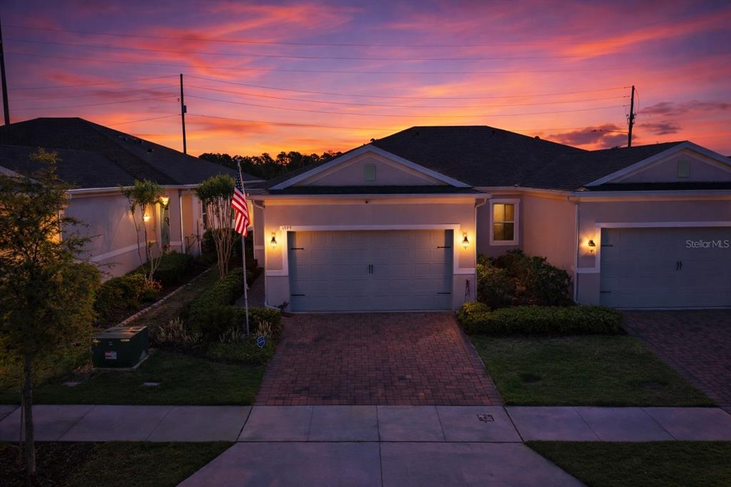 A beige single-story house with a two-car garage and a paved driveway — 1999 KEY BAY TRAIL, KISSIMMEE, FL