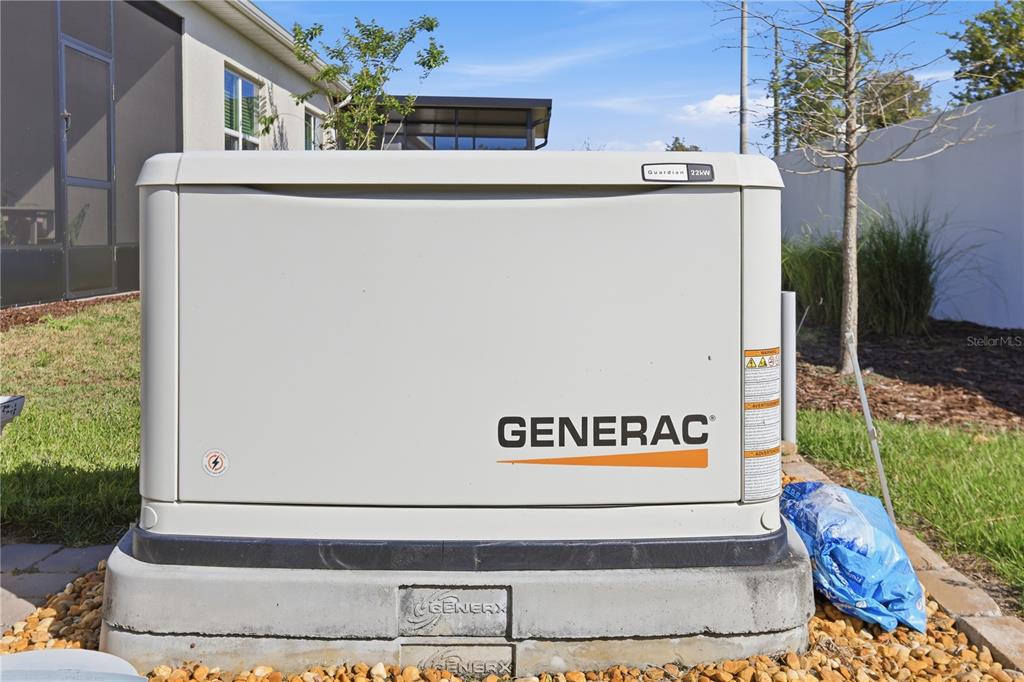 A beige Generac Guardian 22kW standby generator sits on a concrete pad outdoors — 1999 KEY BAY TRAIL, KISSIMMEE, FL