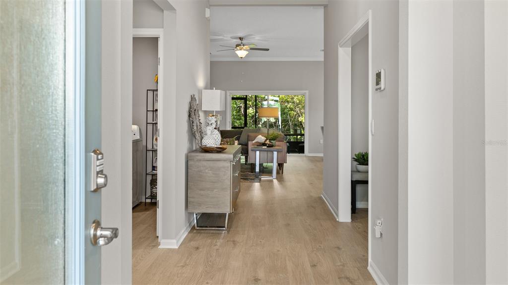 An entryway leads into a living area with light wood flooring and a ceiling fan — 107 GREEN CIRCLE, PALM COAST, FL