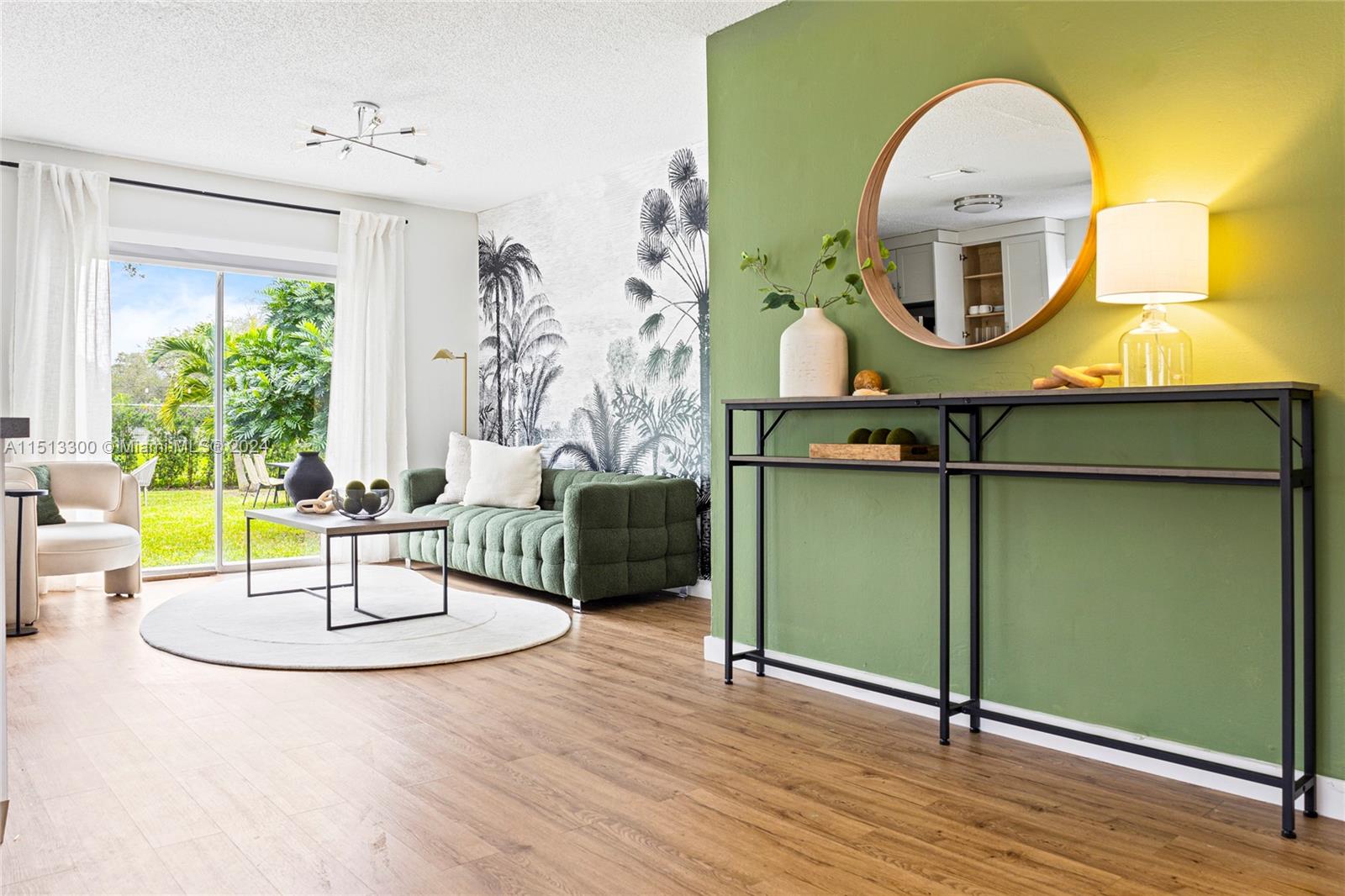 A living room features a green accent wall, a palm-print mural, and a sliding glass door — 20075 SW 87th Pl Side, Cutler Bay FL 33189, CUTLER BAY, FL