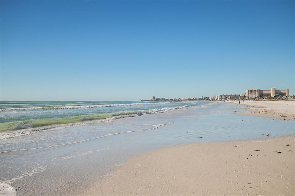 A wide, sandy beach stretches along the ocean under a clear blue sky — 6300 MIDNIGHT PASS ROAD UNIT 21, SARASOTA, FL