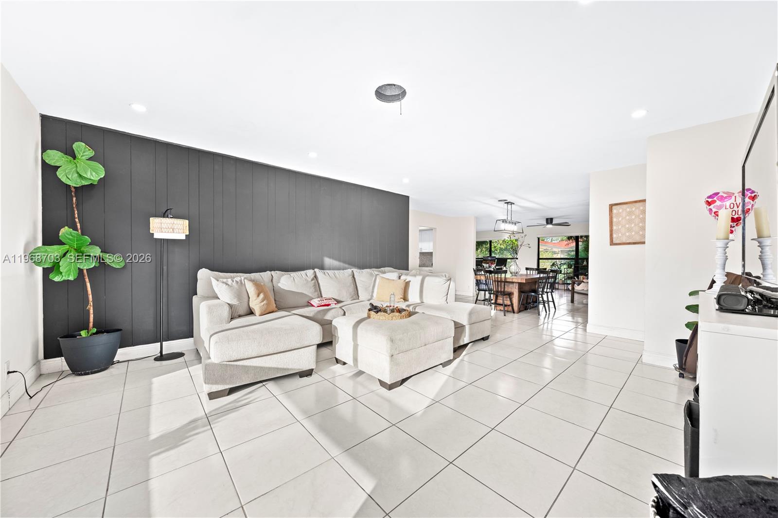 A living room features a large gray sectional sofa against a dark accent wall — 7835 W 16th Ct, Hialeah FL 33014, HIALEAH, FL