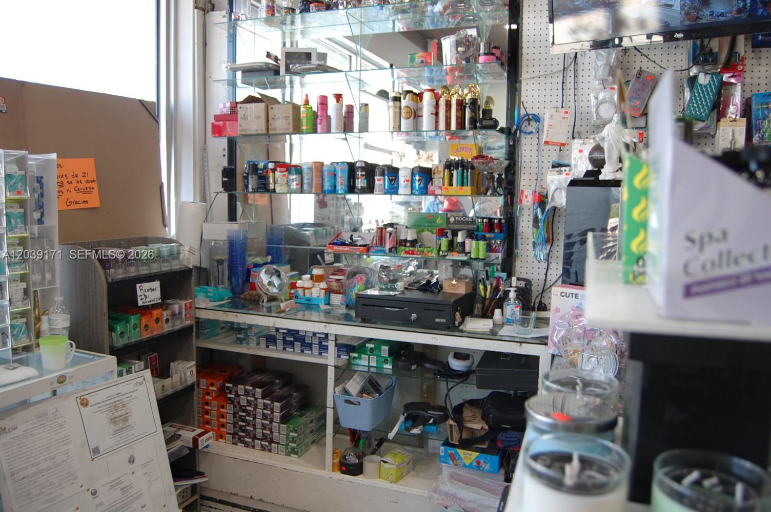 A retail store counter features glass shelving stocked with various personal care and tobacco products — 1900 e 4th ave, Hialeah FL 33010, HIALEAH, FL