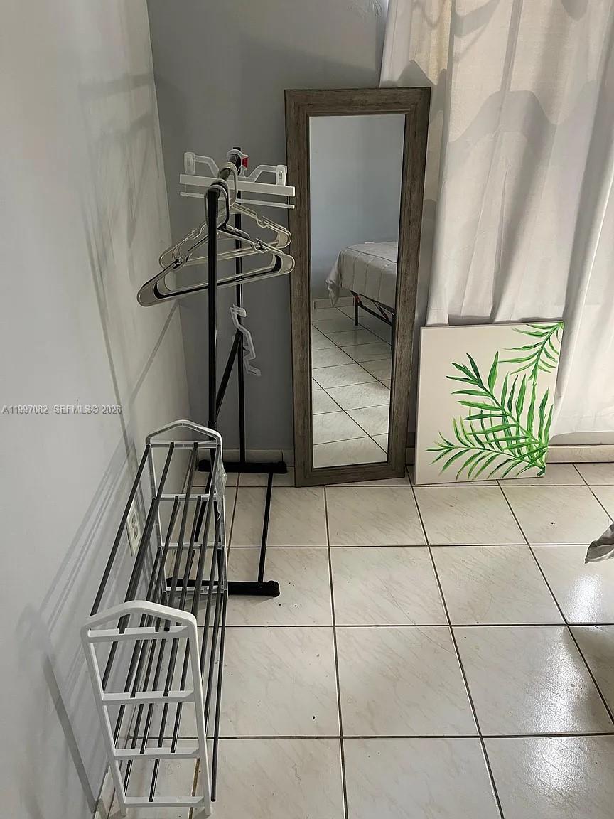 A room features a shoe rack, a garment rack with hangers, a mirror, and artwork — 638 SW 15th Ave, Miami FL 33135, MIAMI, FL