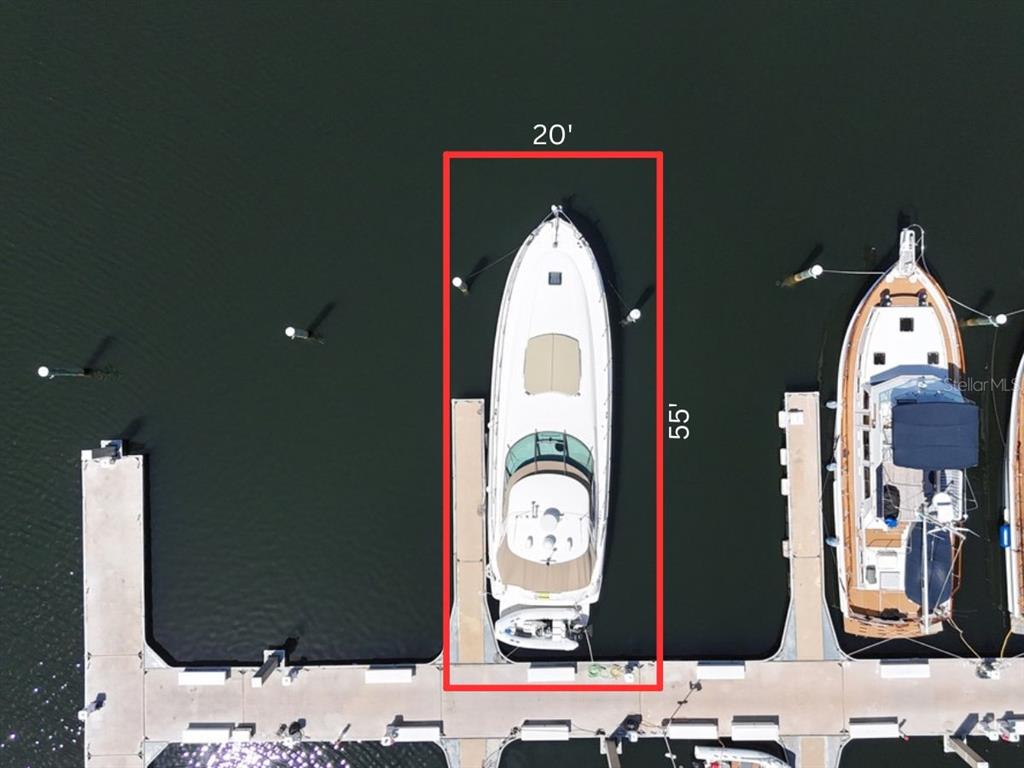 An aerial view shows a boat docked in a slip measuring 20 feet by 55 feet — 102 RIVIERA DUNES WAY UNIT S-55, PALMETTO, FL