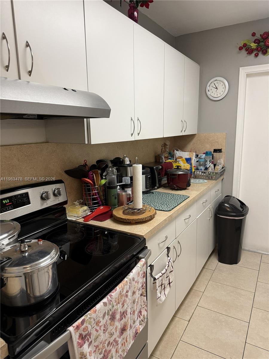 A kitchen features white cabinets, a stainless steel range, and a tan countertop — 7845 Miller Dr # A204, Miami FL 33155, MIAMI, FL