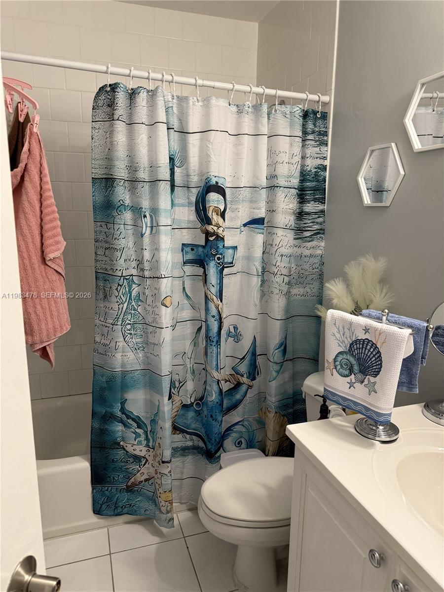 A bathroom features a nautical-themed shower curtain, white subway tile, and a white vanity — 7845 Miller Dr # A204, Miami FL 33155, MIAMI, FL