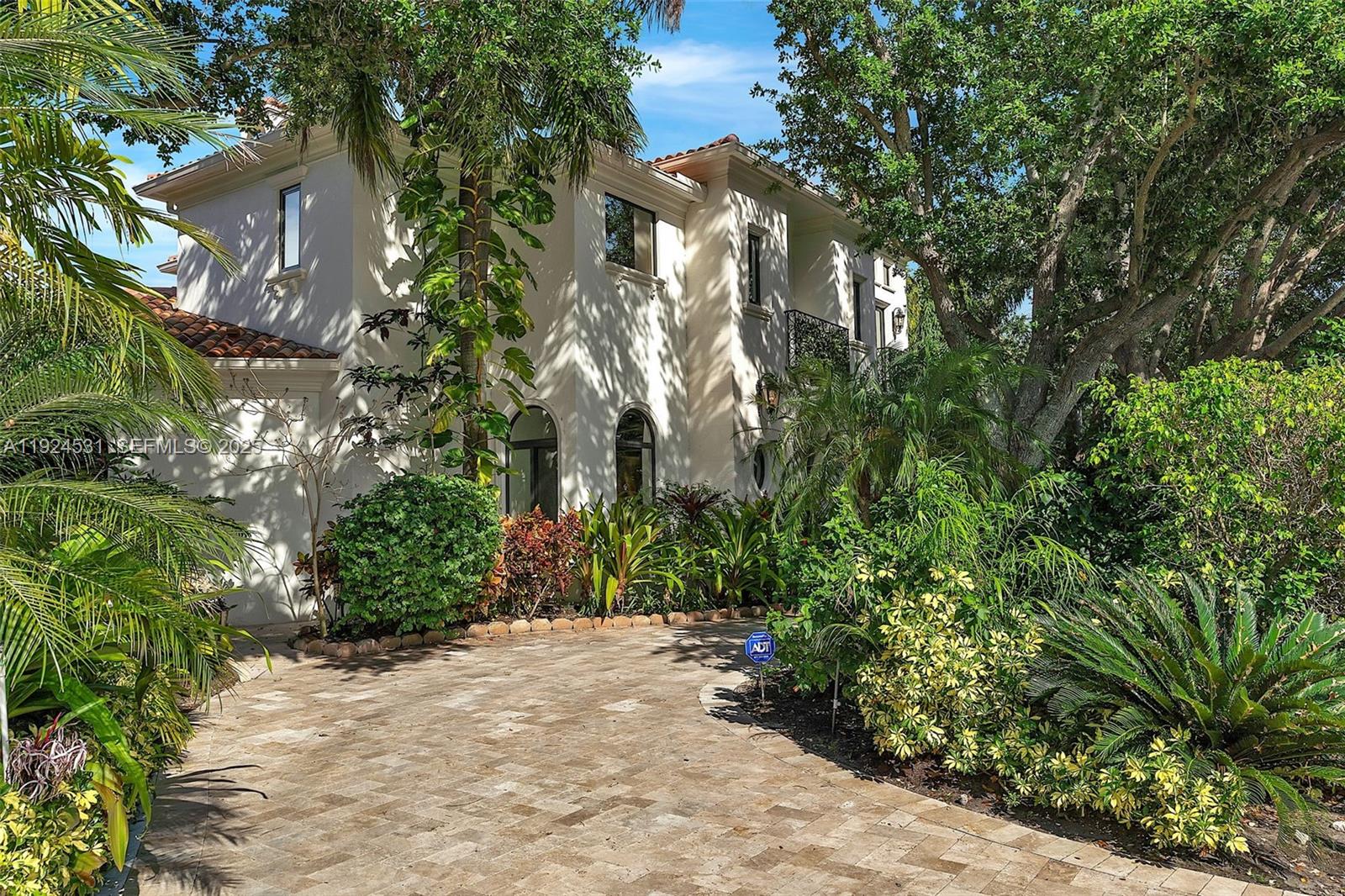 A two-story stucco house with a paved driveway and lush tropical landscaping — 4008 Sanctuary Ln, Boca Raton FL 33431, BOCA RATON, FL