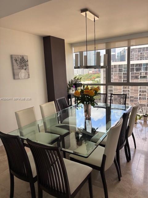 A dining room features a glass table, six chairs, and a modern rectangular pendant light — 2025 Brickell Ave # 1903, Miami FL 33129, MIAMI, FL
