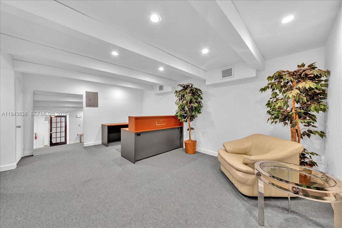 An office reception area features gray carpeting, a desk, a beige sofa, and a potted plant — 500 NE 25th St # 10, Pompano Beach FL 33064, POMPANO BEACH, FL