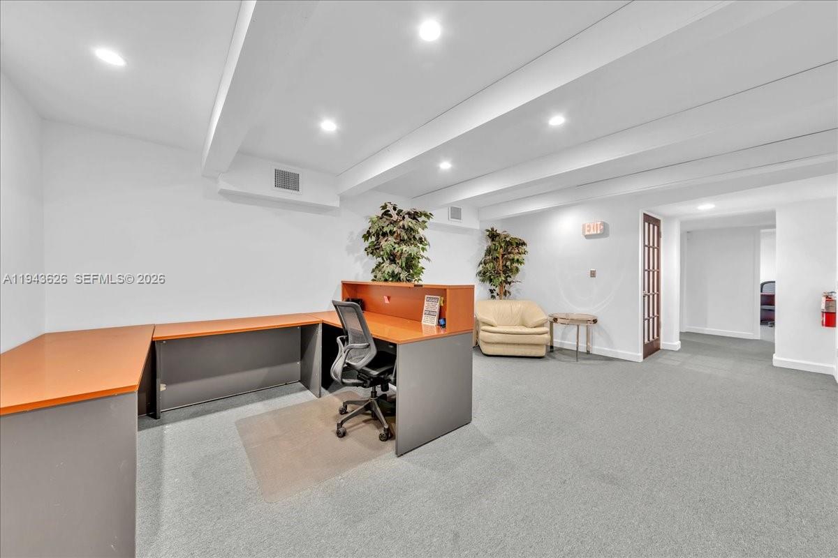 An office space features a large L-shaped desk, a chair, and a beige armchair — 500 NE 25th St # 10, Pompano Beach FL 33064, POMPANO BEACH, FL