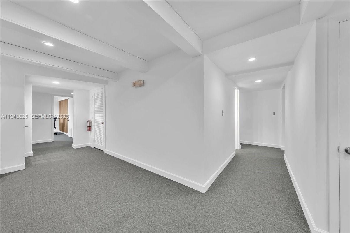 A white hallway with gray carpeting leads to an open room with recessed lighting — 500 NE 25th St # 10, Pompano Beach FL 33064, POMPANO BEACH, FL