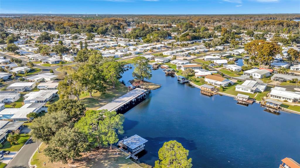 An aerial view shows a canal winding through a residential community with mobile homes — 722 LANDRY LANE, TAVARES, FL