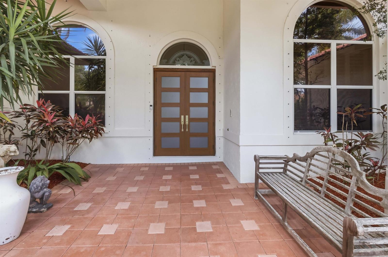 A front entrance features a double wooden door with frosted glass panels and arched windows — 7079 NW 68th Drive, Parkland FL 33067, PARKLAND, FL