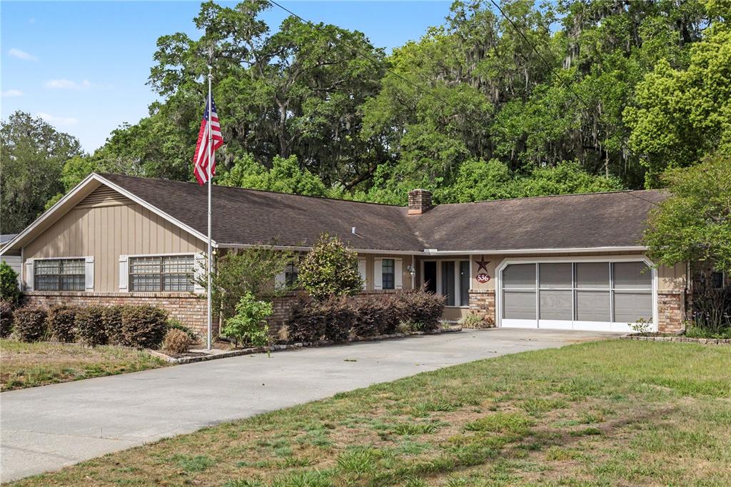 A single-story house with a brick and siding exterior, a concrete driveway, and a flagpole — 536 NE 40TH AVENUE, OCALA, FL