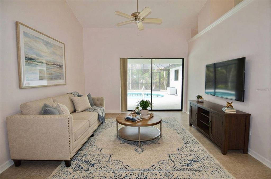A living room features a beige sofa, a round coffee table, and a sliding glass door — 6514 N BISCAYNE DRIVE, NORTH PORT, FL