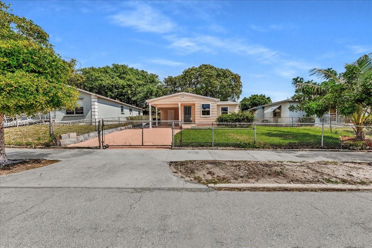 A single-story house with a carport and a chain-link fence sits behind a sidewalk — 837 30th St, West Palm Beach FL 33407, WEST PALM BEACH, FL