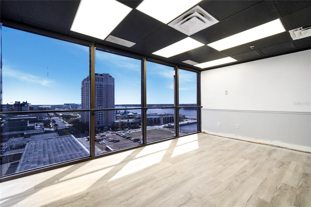 An empty office space features floor-to-ceiling windows with a city and waterfront view — 233 E BAY STREET UNIT 1101, JACKSONVILLE, FL