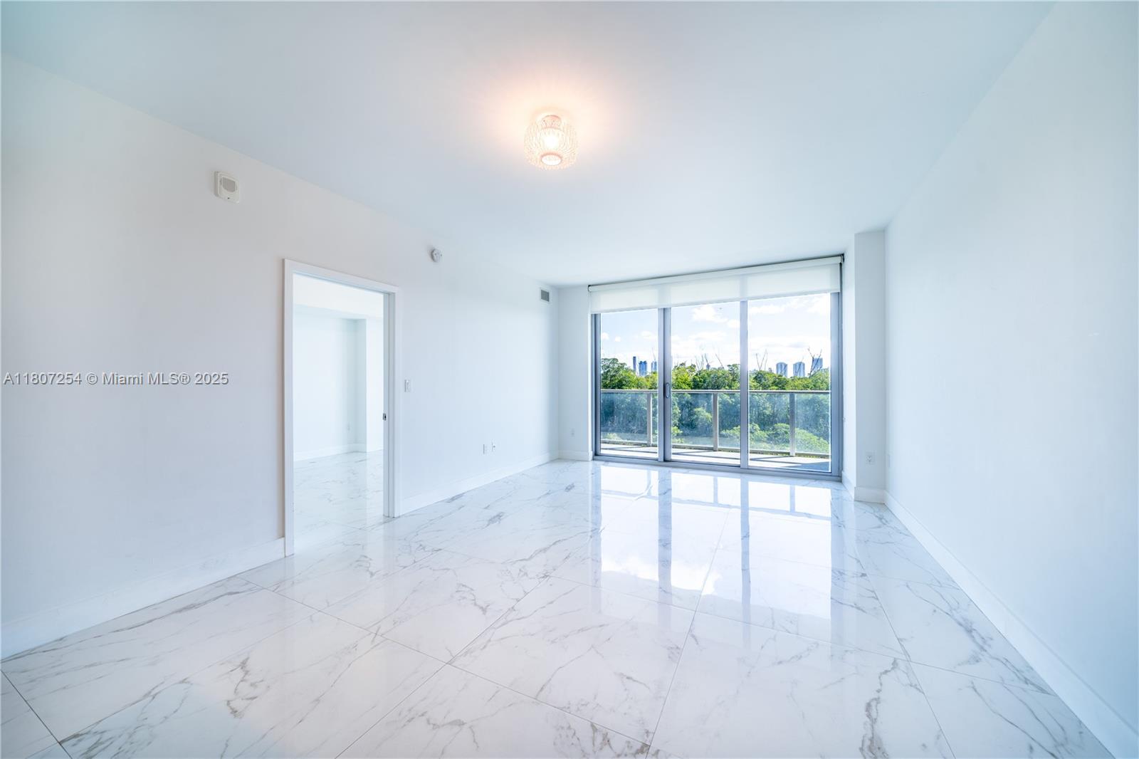 An empty room features white marble-look tile flooring, a ceiling light fixture, and floor-to-ceiling windows — 16385 Biscayne Blvd # 417, North Miami Beach FL 33160, NORTH MIAMI BEACH, FL