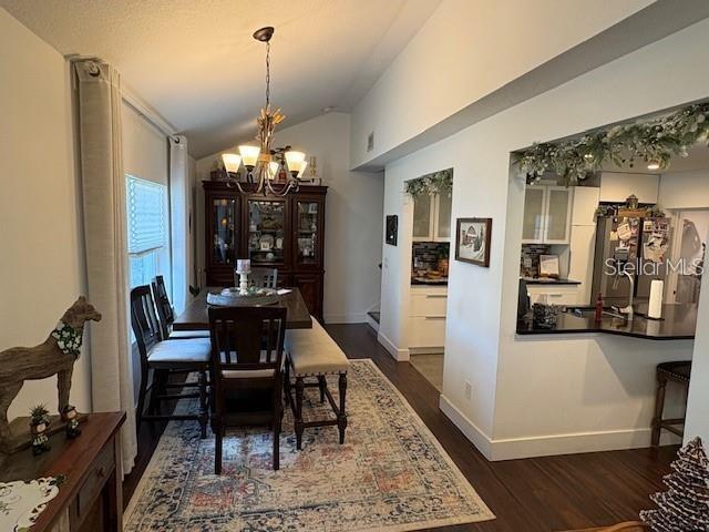 A dining area with a chandelier and hutch opens into a kitchen with a breakfast bar — 1830 STAUNTON AVENUE, WINTER PARK, FL