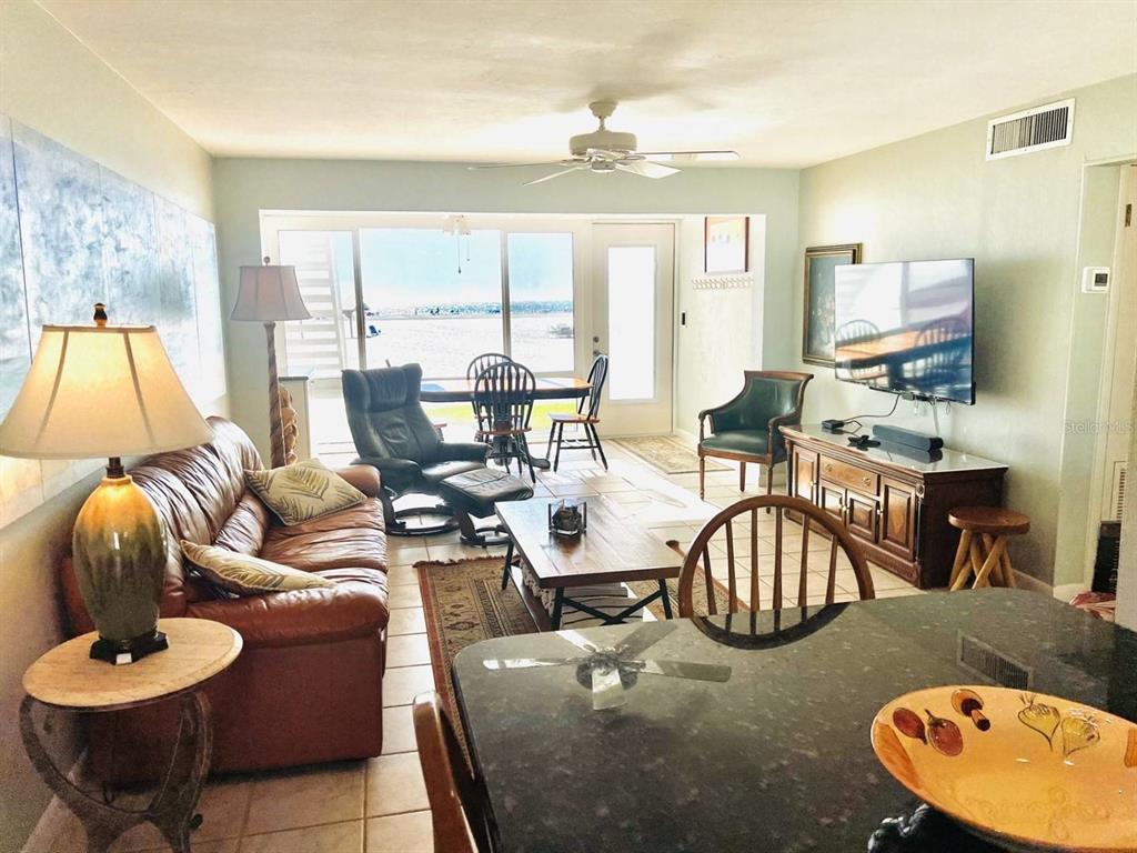 A living room with a leather sofa, wooden coffee table, and a view of the beach — 6006 MIDNIGHT PASS ROAD UNIT 40, SARASOTA, FL