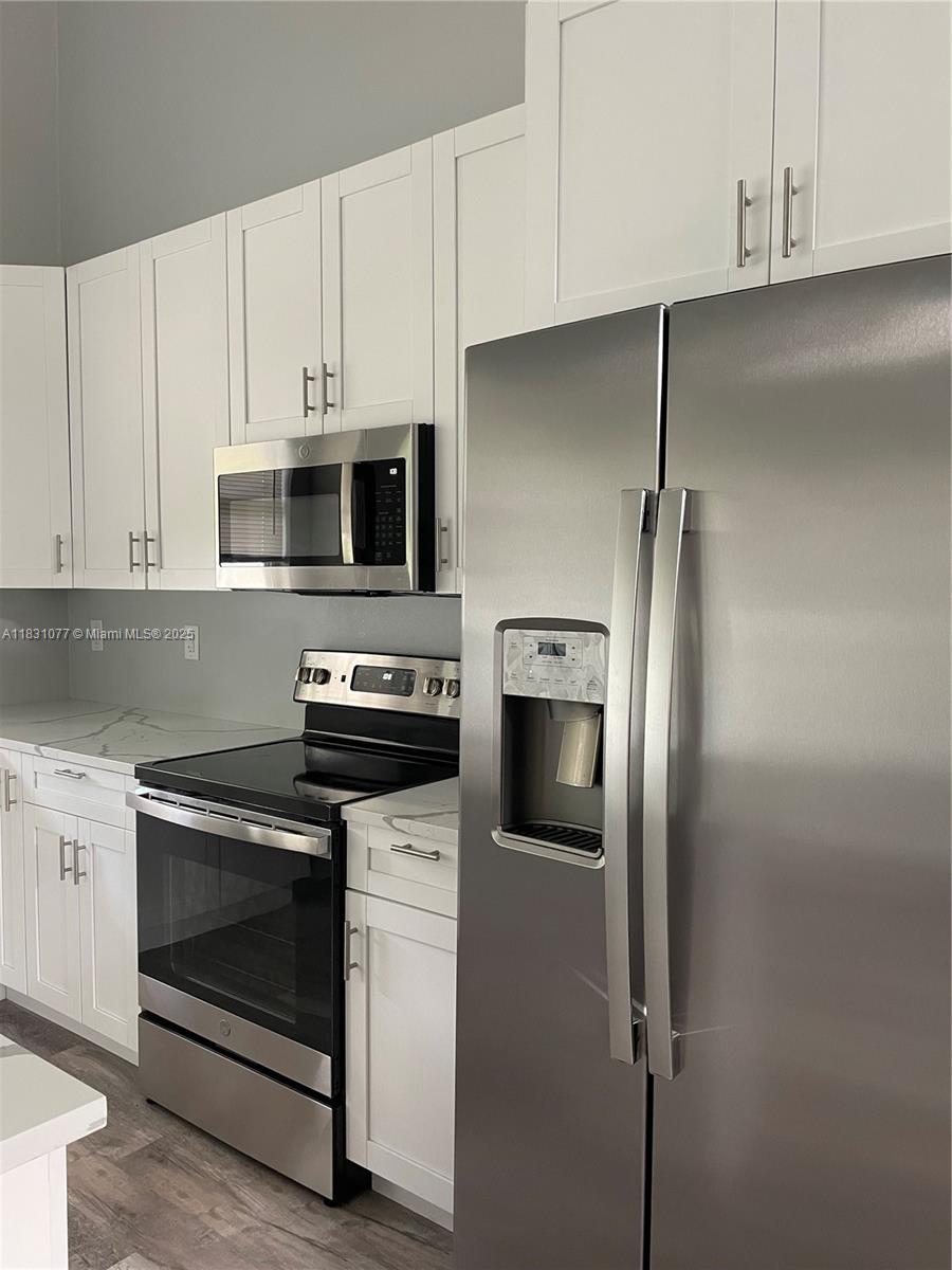 A modern kitchen features white shaker cabinets, stainless steel appliances, and a side-by-side refrigerator — 2550 N ArrowHead RD # 2550, Avon Park FL 33825, AVON PARK, FL