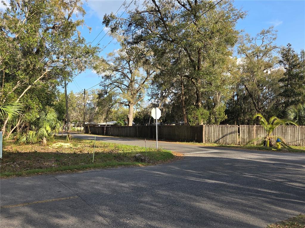 An outdoor view of a street corner featuring a stop sign and a wooden fence — (Parcel 1) 214 NE 13TH AVENUE, GAINESVILLE, FL