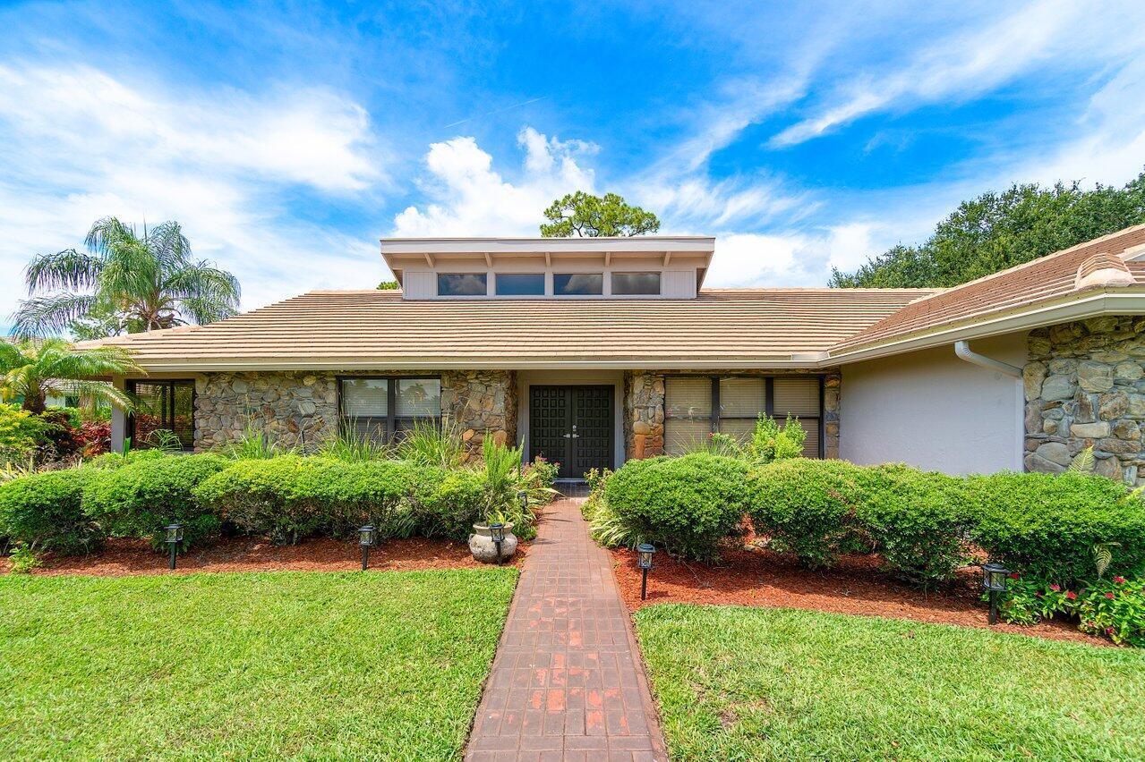 A single-story house with a stone facade, a brick walkway, and a central clerestory window — 9405 Dundee Drive, Lake Worth FL 33467, LAKE WORTH, FL