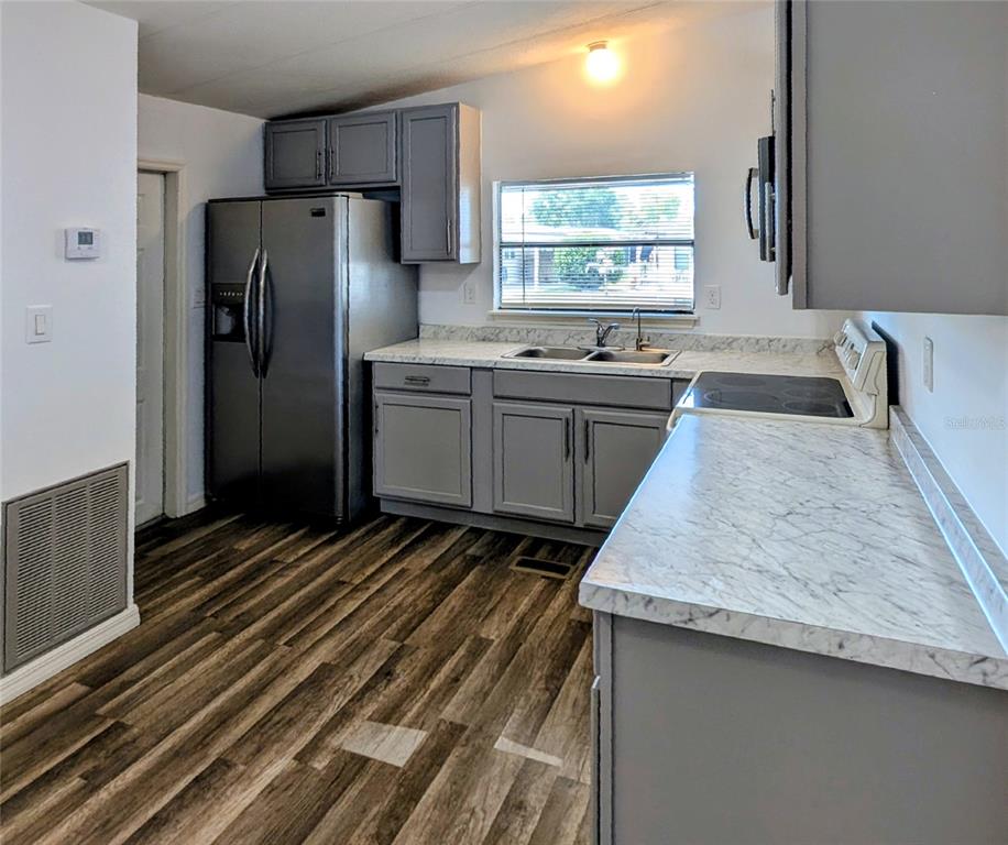 A kitchen features gray cabinets, stainless steel appliances, and white marble-patterned countertops — 34351 TIMBERLAND BOULEVARD, WESLEY CHAPEL, FL