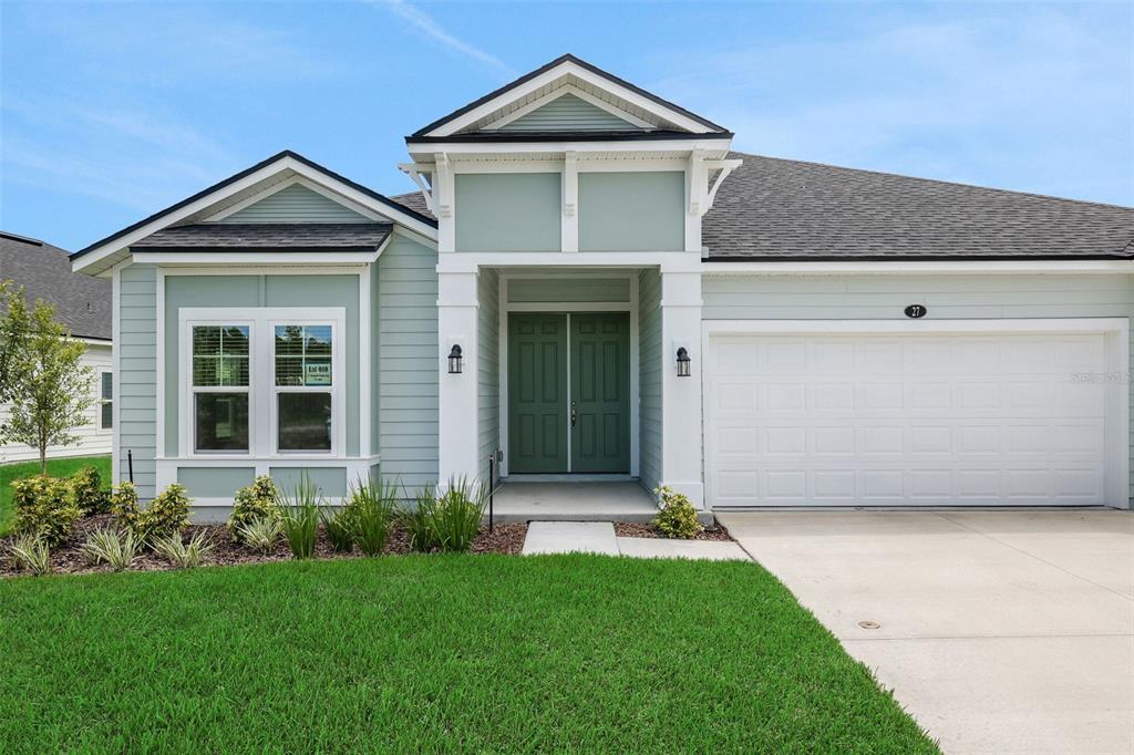 A light green single-story house with a white garage and a double front door — 27 WINDMILL PALM WAY, PALM COAST, FL