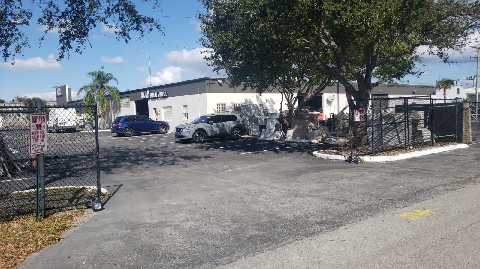 A commercial building with a parking lot, stone slabs, and a chain-link fence — 1815 10th Avenue N # C, FL 33461, FL