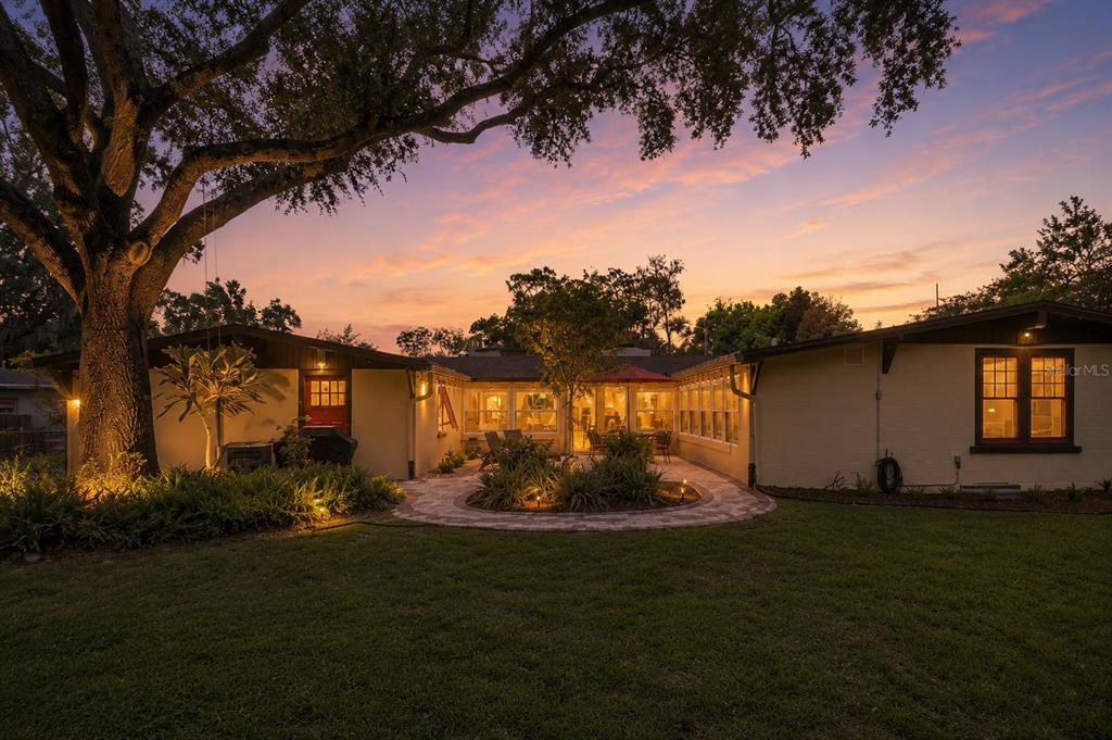 A single-story house with a brick driveway and a large front lawn under mature trees — 497 VALENCIA STREET, SANFORD, FL