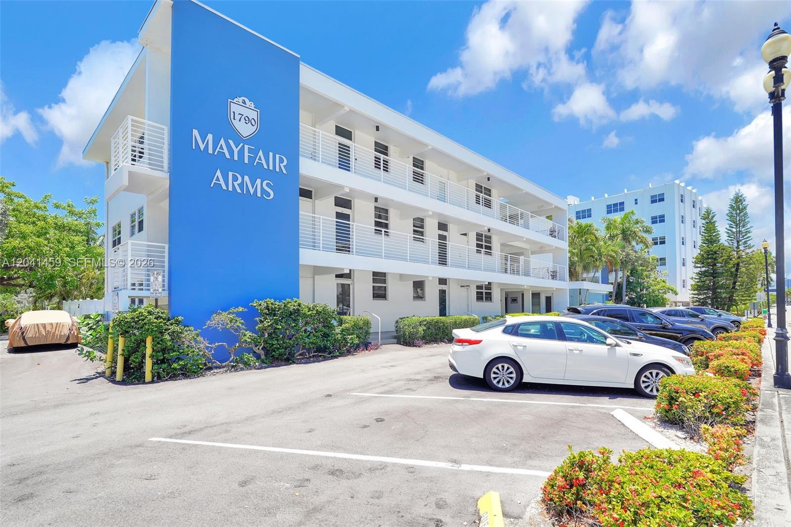 A three-story apartment building with a blue facade and white balconies stands above a parking lot — 1790 E Las Olas Blvd # 11, Fort Lauderdale FL 33301, FORT LAUDERDALE, FL