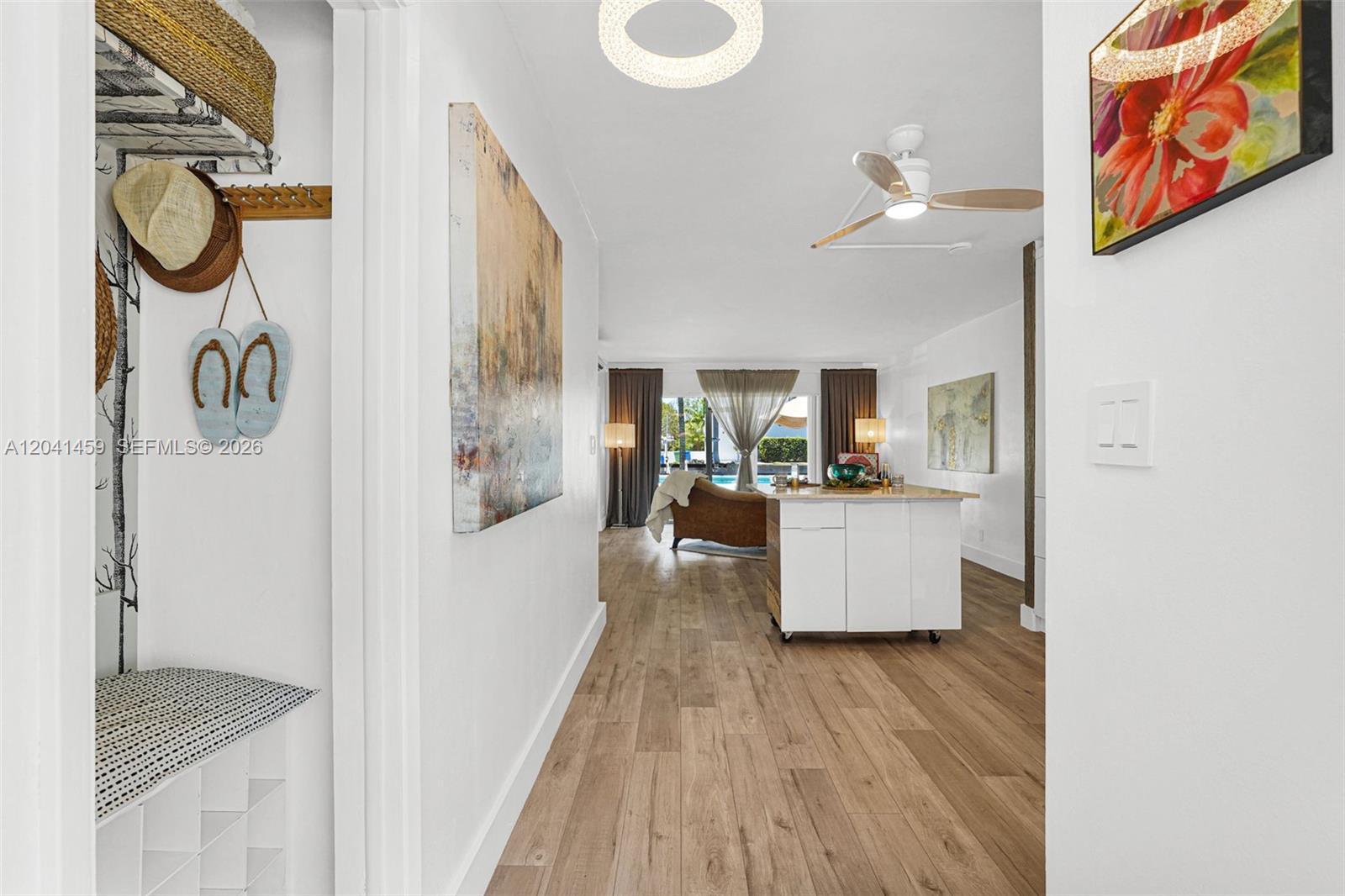 A hallway with wood-look flooring leads into a living area with a kitchen island — 1790 E Las Olas Blvd # 11, Fort Lauderdale FL 33301, FORT LAUDERDALE, FL