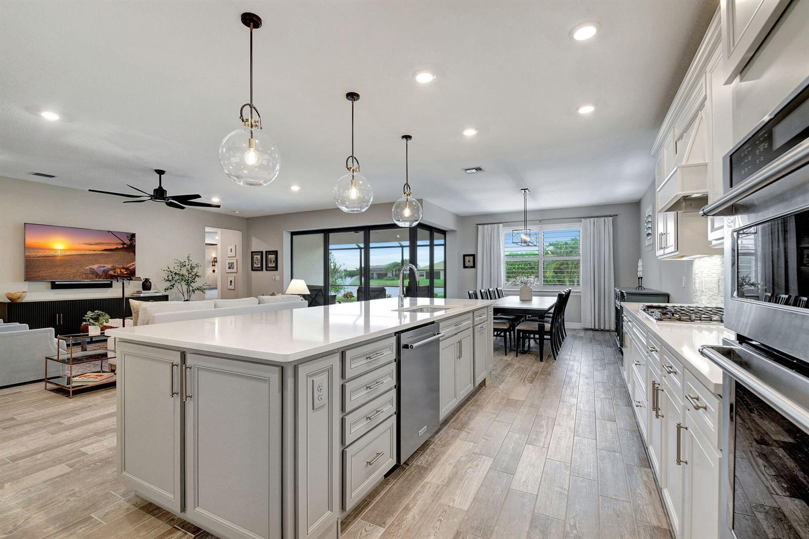 A modern kitchen with a large island, white cabinetry, and stainless steel appliances — 8433 Vaulting Drive, Lake Worth FL 33467, LAKE WORTH, FL