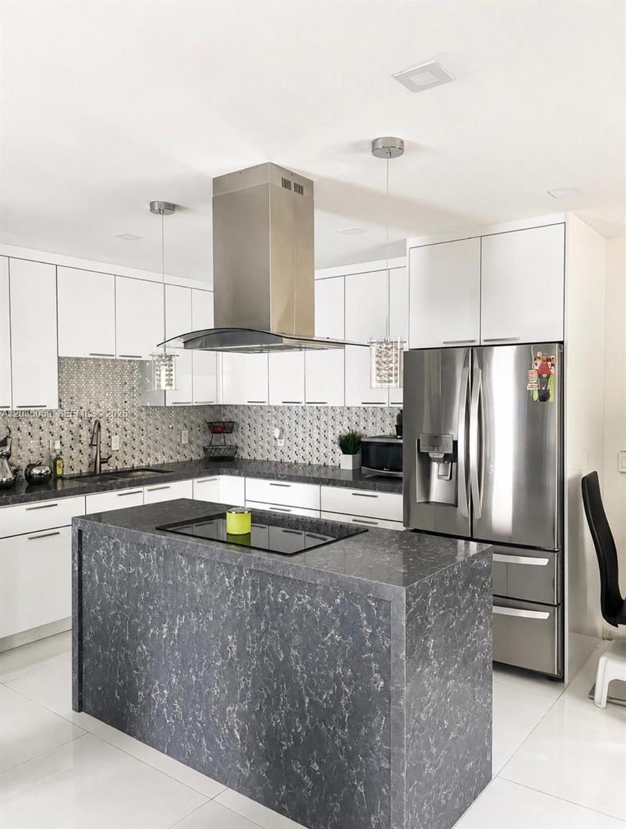 A modern kitchen features white cabinets, a dark gray marble-patterned island, and stainless steel appliances — 1220 N 71st Ter, Hollywood FL 33024, HOLLYWOOD, FL