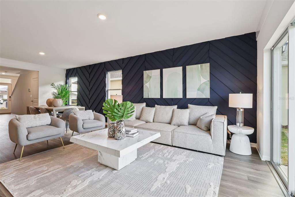 A living room features a dark navy chevron-patterned accent wall, a light sofa, and marble table — 5168 PENELOPE TRAIL, LAKELAND, FL