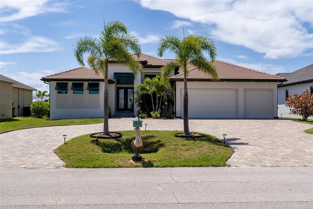 A single-story house with a tiled roof, a paved driveway, and two palm trees — 15252 CHINOOK WAY, PORT CHARLOTTE, FL