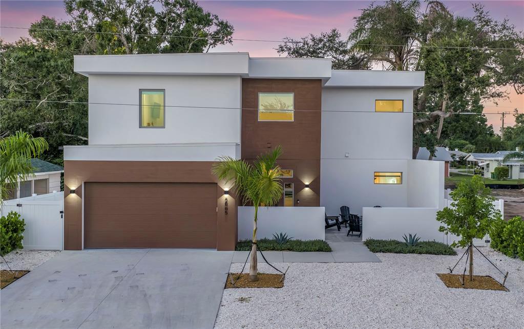 A modern two-story house with a brown garage, white stucco walls, and a gravel front yard — 2065 GOLDENROD STREET, SARASOTA, FL