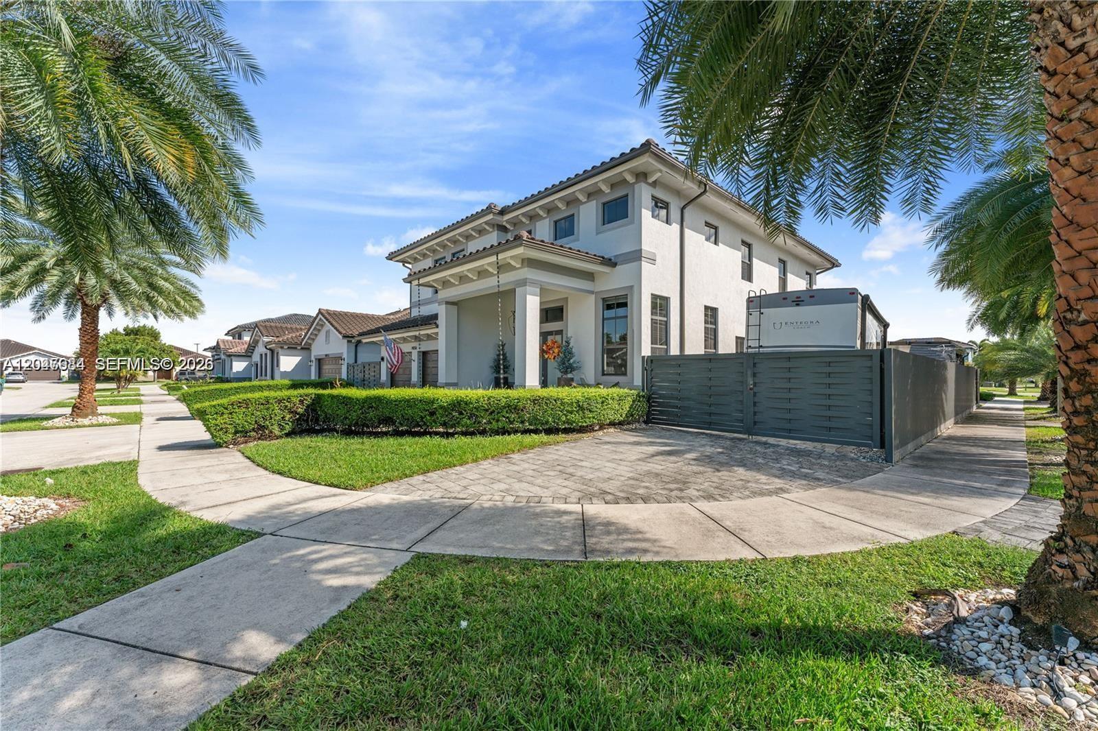 A two-story house with a paved driveway, a side fence, and a parked recreational vehicle — 14856 SW 27th Ter, Miami FL 33185, MIAMI, FL