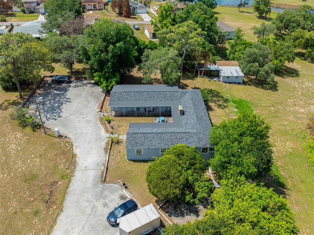 An aerial view shows an L-shaped building with a gray roof and a parking lot — 1210 STATE 17 ROAD S, DUNDEE, FL