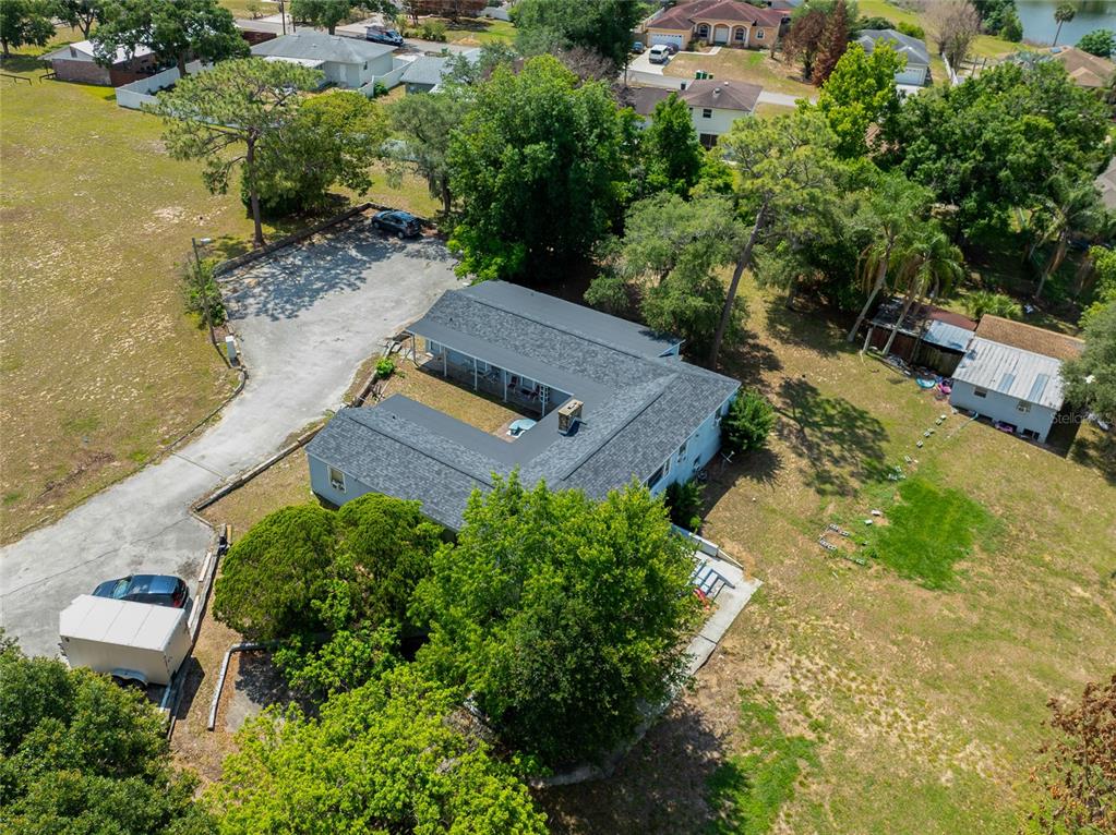 An aerial view shows an L-shaped house with a dark roof and a large yard — 1210 STATE 17 ROAD S, DUNDEE, FL