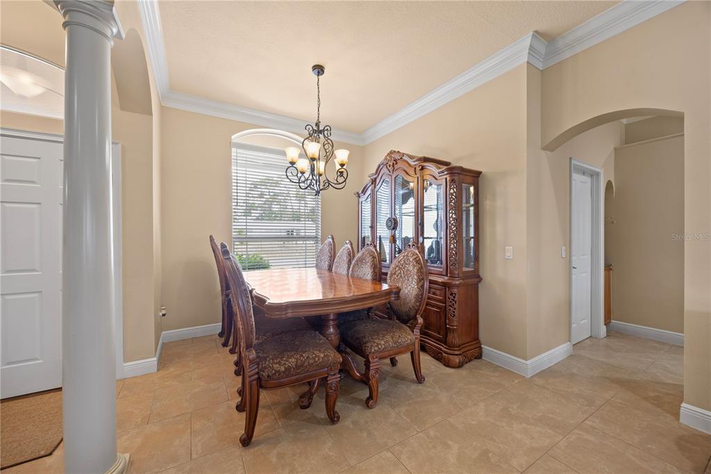 A formal dining room features a wooden table, upholstered chairs, a hutch, and tile flooring — 1276 RAMROD STREET, NORTH PORT, FL