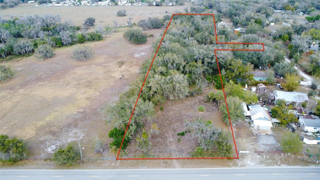 An aerial view shows a vacant, wooded lot outlined in red along a paved road — DURRANCE STREET SE, ARCADIA, FL
