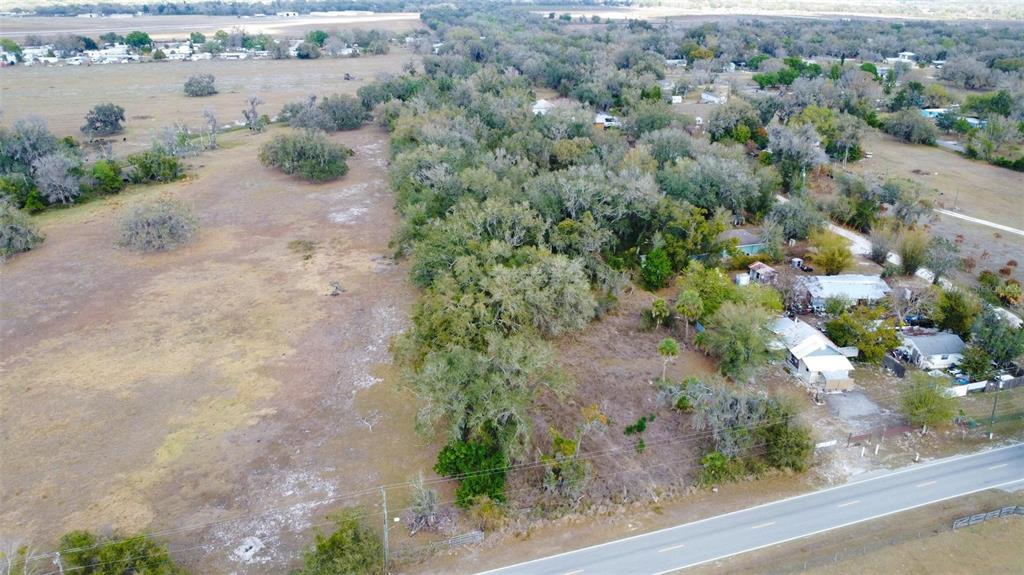 An aerial view shows a rural property with trees, open land, and nearby houses — DURRANCE STREET SE, ARCADIA, FL