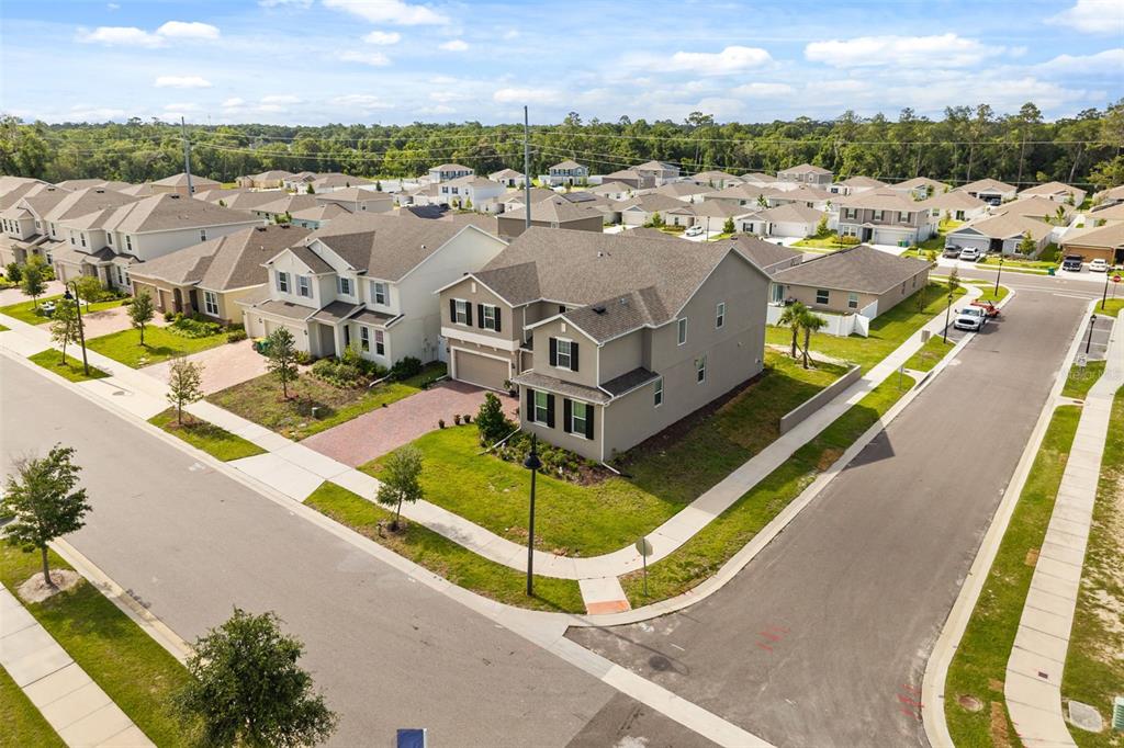 An aerial view shows a two-story suburban house on a corner lot with landscaping — 1299 WOODLINE DR, DELAND, FL