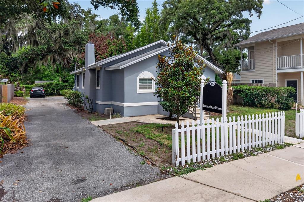A gray single-story building with a white picket fence and a counseling offices sign — 813 N FERN CREEK AVENUE, ORLANDO, FL